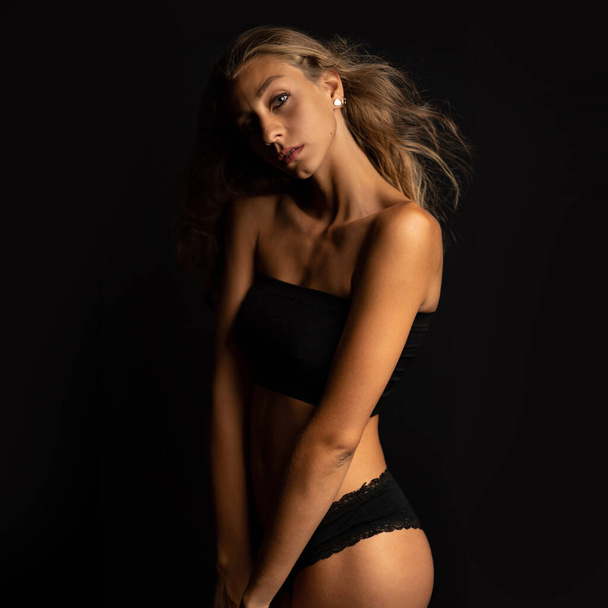 Sexy blonde woman portrait with black underwear isolated on dark background. Studio portrait. - Foto, imagen