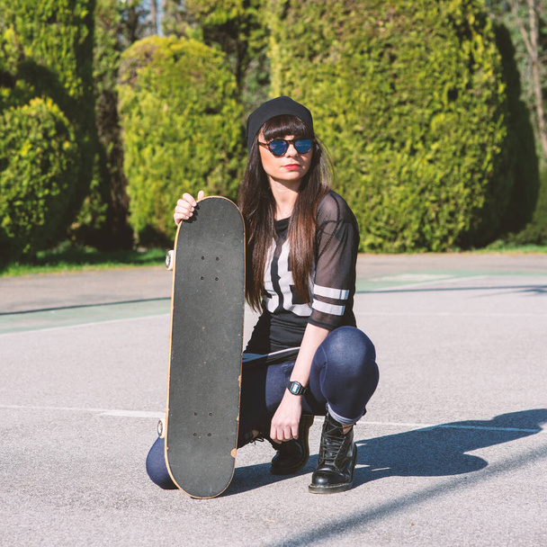 Young woman portrait with skateboard outdoors. Life style. - Фото, изображение