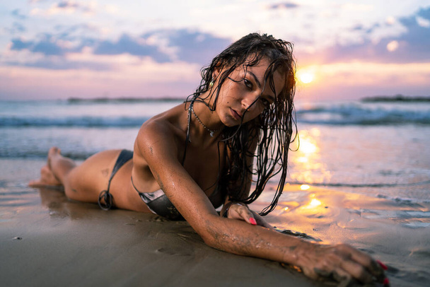 Сексуальна молода жінка крупним планом портрет в бікіні на пляжі. Сонячне світло з драматичним освітленням
. - Фото, зображення