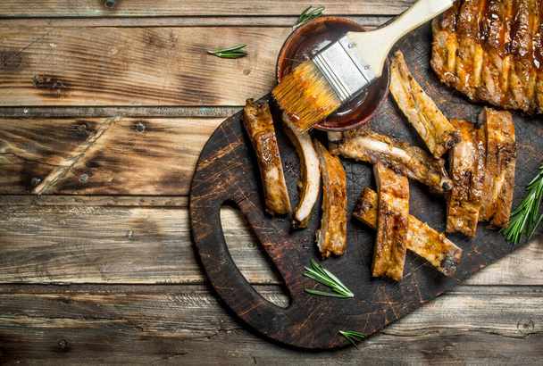 Chopped ribs grilled with a sauce. On a wooden background. - Foto, Imagen