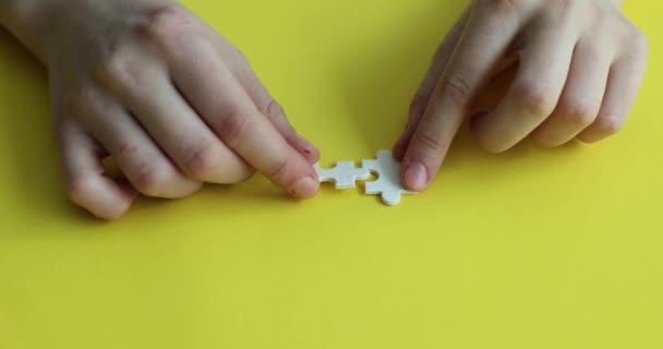 Frauenhände verbinden Elemente des weißen Puzzlekonzepts. logisches Denken und Persönlichkeitsentwicklung - Filmmaterial, Video