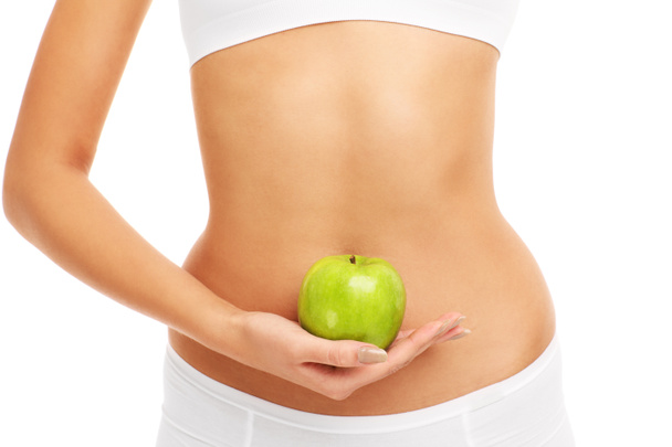 Manzana verde sobre el vientre
 - Foto, imagen