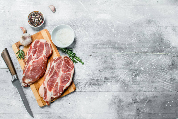 Raw pork steaks with salt and spices. On a rustic background. - Photo, Image
