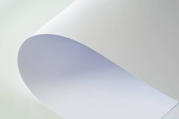 Ένα μεγάλο φύλλο λευκού χαρτιού σε ελαφρύ φόντο. - Φωτογραφία, εικόνα