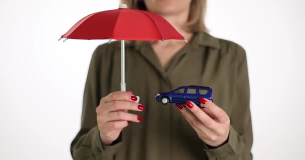 Kobieta trzyma parasol nad samochodem. Symbol ochrony samochodu. Automatyczne ubezpieczenia i płatności gotówkowe - Materiał filmowy, wideo