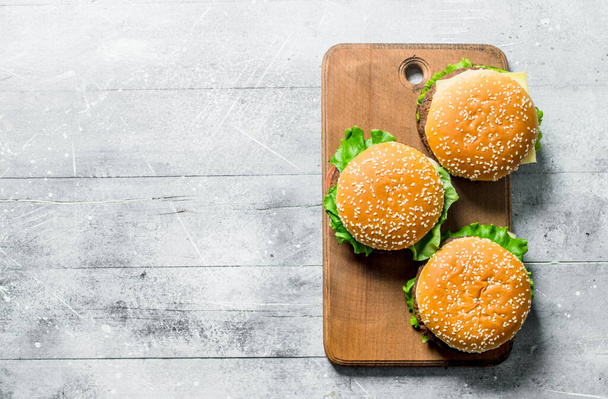 Burgers on the cutting Board. On white wooden background - Foto, immagini