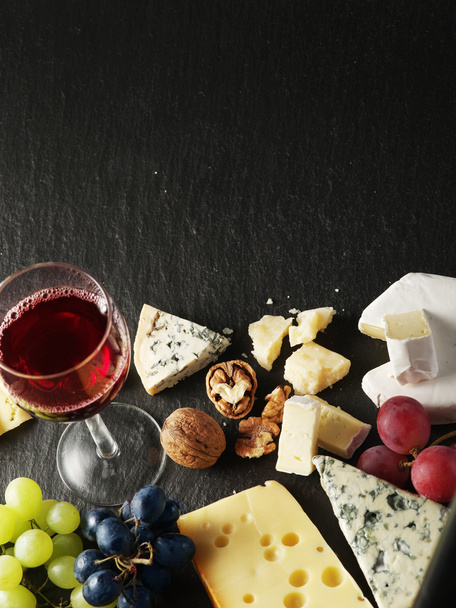 Different types of cheeses with wine glass and fruits. - 写真・画像