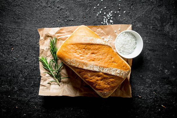 Crunchy bread with rosemary and salt. On black rustic background - 写真・画像