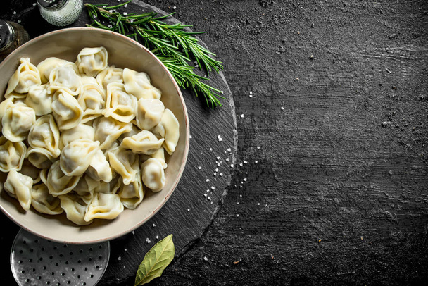 Dumplings with spices and rosemary. On black rustic background - 写真・画像