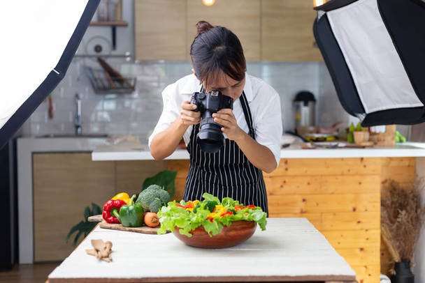 photographer food , asian women is taking pictures of food her food in studio. - 写真・画像