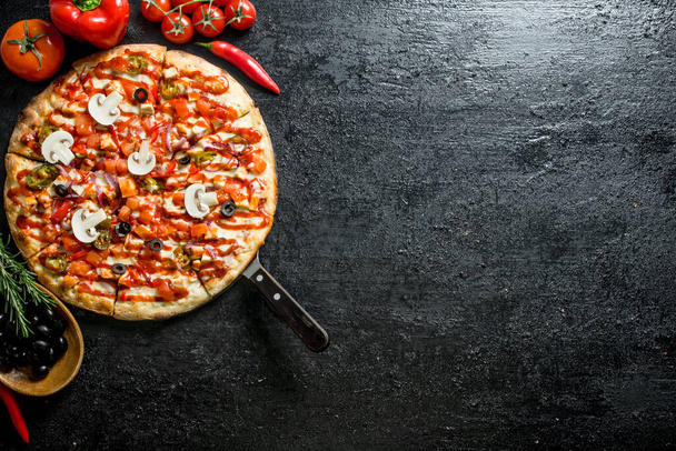 Pizza with olives, sausages and tomatoes. On black rustic background - Fotoğraf, Görsel