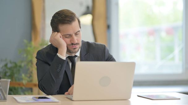 Zmęczony biznesmen śpiący podczas siedzenia w biurze - Zdjęcie, obraz