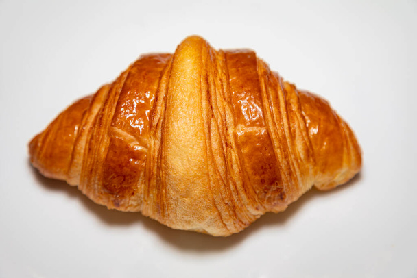 Golden brown butter croissant with shadow isolated on the plain background. - Foto, Imagem