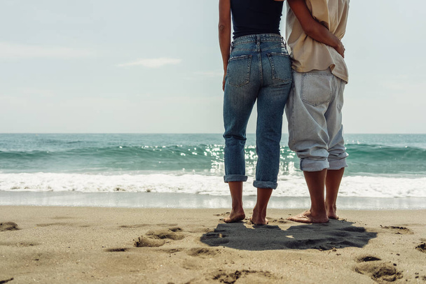 a guy and a girl are standing on the seashore embracing love hap - Foto, afbeelding