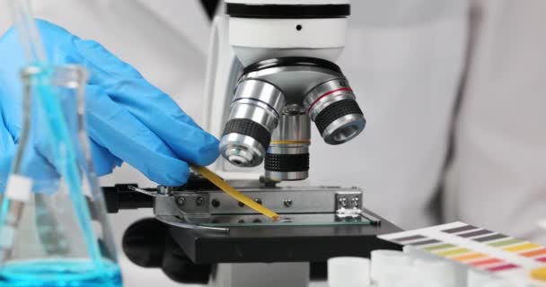Vědec chemik drží v ruce ph tekutý test s mikroskopem detailní. Chemická analýza a složení vody - Záběry, video