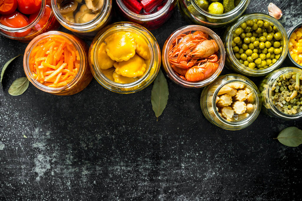 Preserved food in glass jars. On dark rustic background - Photo, Image