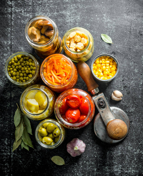 Pickled food in glass jars. On dark rustic background - Fotoğraf, Görsel