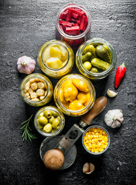 Pickled vegetables in glass jars. On black rustic background - Photo, Image