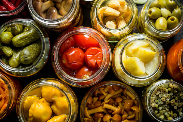 Preserved vegetables in glass jars. Top view - Foto, Bild