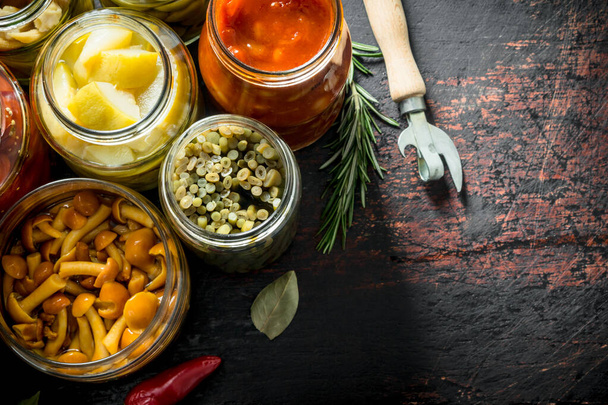 Jars with a variety of pickled vegetables. On dark rustic background - Photo, Image