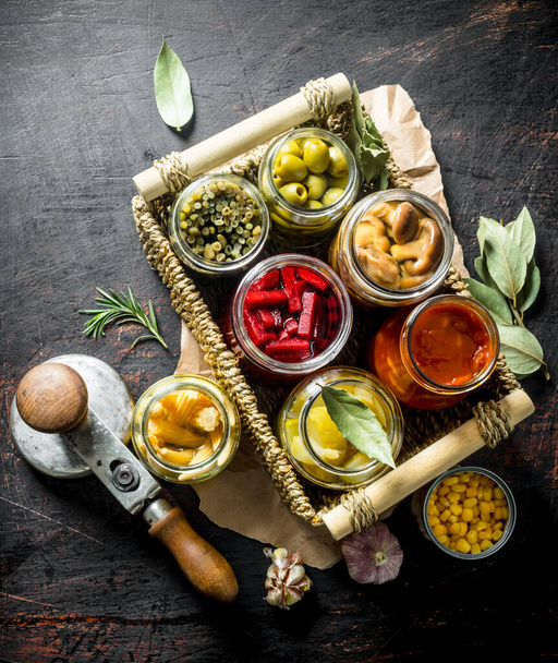 Homemade pickled vegetables in jars on the tray. On dark rustic background - Fotoğraf, Görsel