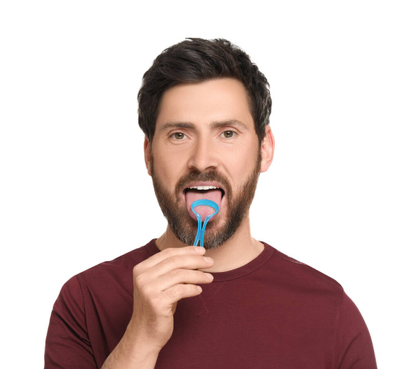 Handsome man brushing his tongue with cleaner on white background - Фото, изображение
