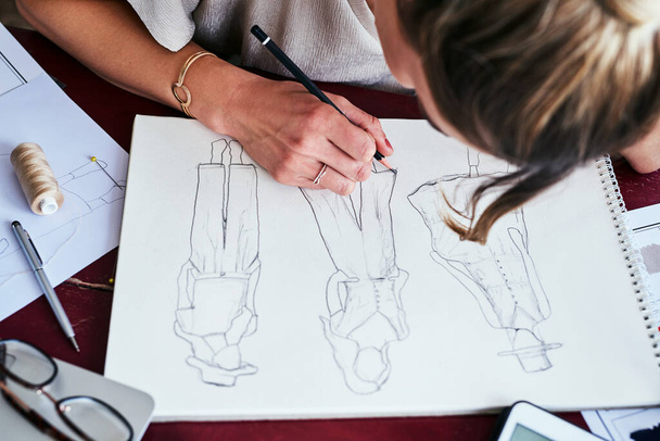 Mujer, manos y diseño de moda dibujo sobre papel para la planificación, idea o boceto en el escritorio de la oficina de arriba. Mano de mujer creativa, artista o diseñadora gráfica para ideas de bocetos de ropa para startup. - Foto, imagen