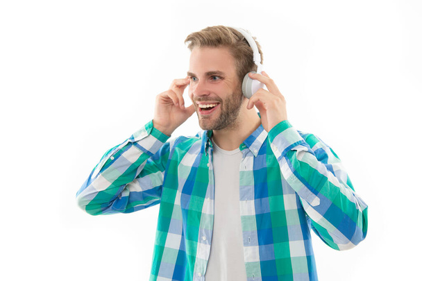 positive millennial man listening music on background. photo of millennial man music lover. millennial man listen music isolated on white. millennial man wear music headphones in studio. - Fotografie, Obrázek