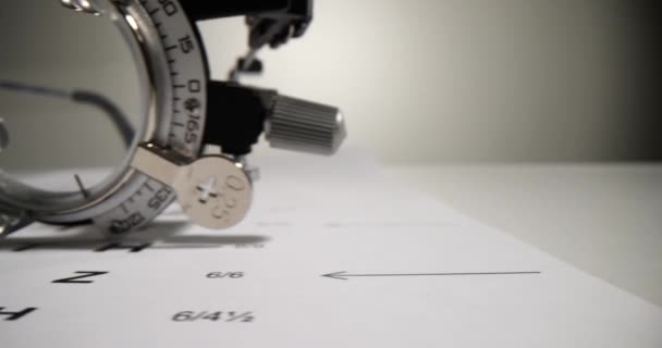 Trial frame and vision chart check on white table. Ophthalmic equipment - Footage, Video