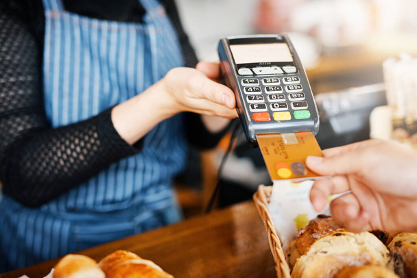 Πληρωμή με πιστωτική κάρτα, αρτοποιείο και τα χέρια με ένα μηχάνημα σε ένα εστιατόριο για μια υπηρεσία ή φαγητό. Καφέ, πληρωμή και πελάτης που πληρώνει ή αγοράζει προϊόν σε καφετέρια με συναλλαγή από εργαζόμενο. - Φωτογραφία, εικόνα