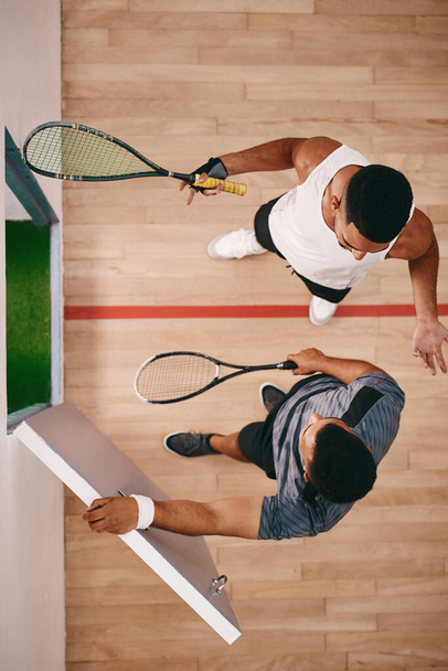Jego dzień squasha i wszyscy zaproszeni. dwóch młodych mężczyzn na czacie po grze w squasha - Zdjęcie, obraz