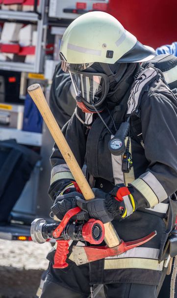 Feuerwehr mit Gasmaske und Spitzhacke im Einsatz - Foto, Bild