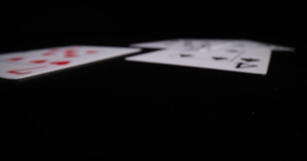 Karty do gry spadają na czarny stół. Online poker i cień biznesu - Materiał filmowy, wideo
