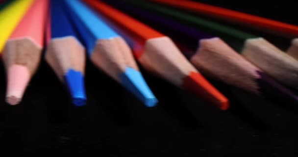 Puntas afiladas de lápices multicolores sobre fondo oscuro. Papelería para la educación y el desarrollo de niños y adultos - Imágenes, Vídeo