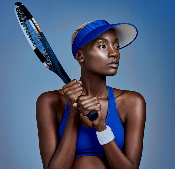 Estou sempre ansioso para o próximo jogo. Estúdio tiro de uma jovem esportiva posando com uma raquete de tênis contra um fundo cinza - Foto, Imagem
