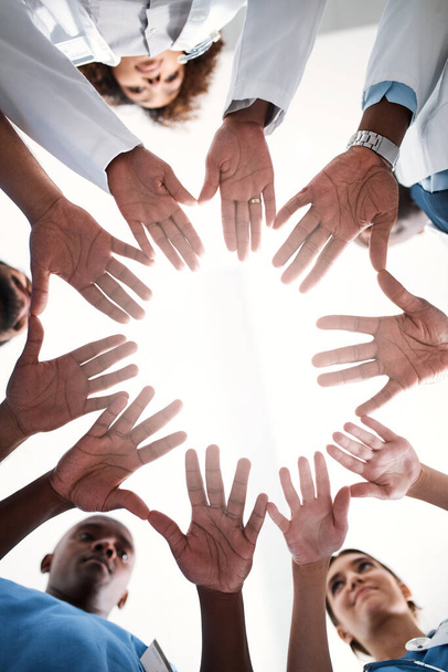 Die Hände, die Wunder vollbringen können. Aufnahme einer Gruppe von Medizinern, die sich in einem Krankenhaus die Hände verbinden - Foto, Bild