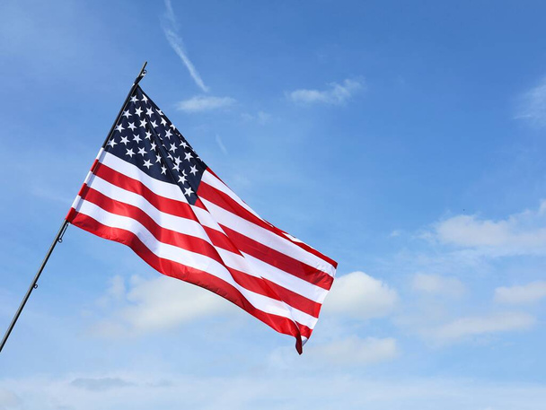 Amerikaanse vlag wappert in een blauwe lucht. Amerikaans vakantieconcept. - Foto, afbeelding
