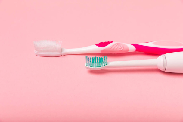 electric toothbrush, bamboo and handmade toothbrushes on a pink background with copy space. Flat lay. Oral hygiene. Oral care kit. Dentist concept. Place for text. Place to copy. - Foto, immagini