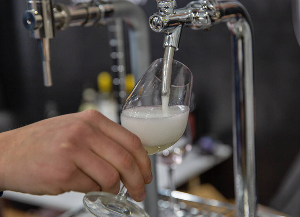 Pouring prosecco sparkling wine from a tap into a glass closeup - Fotó, kép