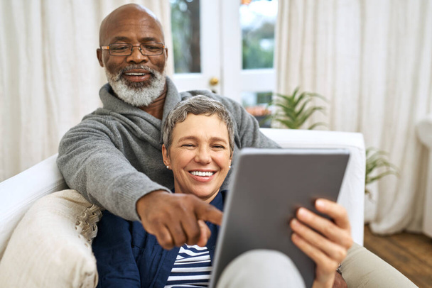 Technik, Senioren-Paar mit Tablet und auf dem Sofa glücklich im Wohnzimmer ihres Hauses. Soziale Medien oder Streaming, Ruhestand oder Entspannung und glückliche Ehepaare auf der Couch lachen mit digitalen Geräten. - Foto, Bild