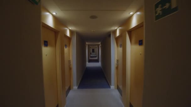 Guick chodzić korytarzem hotelowym z żółtymi drzwiami z numerami pokoi - Materiał filmowy, wideo