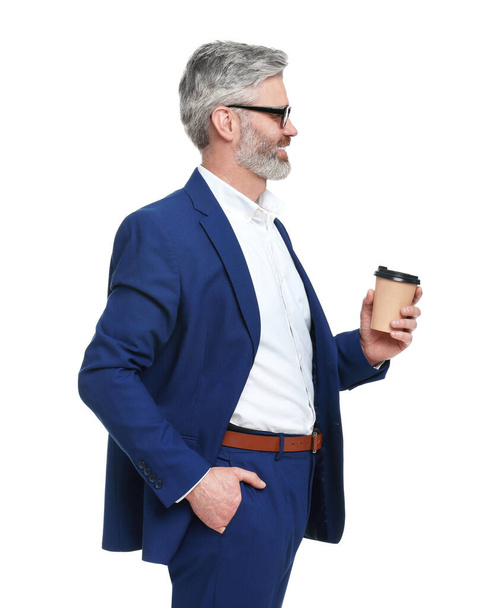 Mature businessman in stylish clothes with cup of drink on white background - 写真・画像