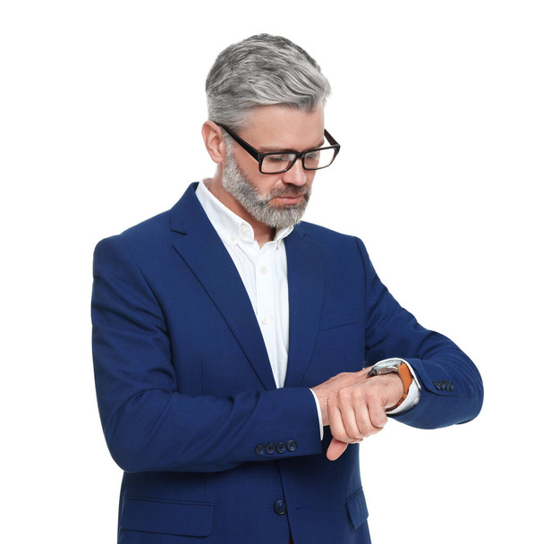 Mature businessman in stylish clothes checking time on white background - Φωτογραφία, εικόνα