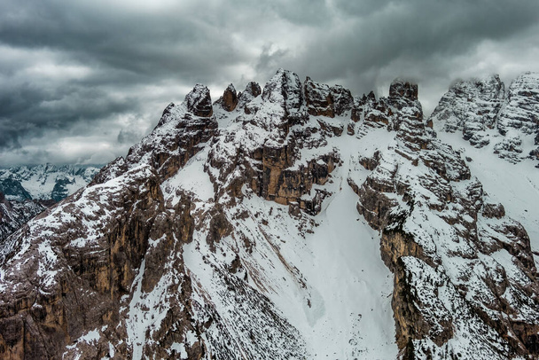 Aerial view of rocky mountains and cloudy sky in Dolomites, Italy - Foto, imagen