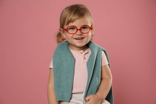 Cute little girl in glasses on pink background - 写真・画像