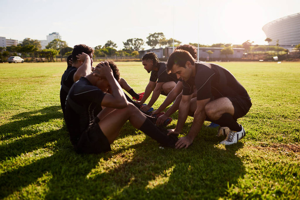 Continuem. Tiro completo de um grupo diversificado de treinamento de esportistas durante uma prática de rugby em um clube esportivo - Foto, Imagem