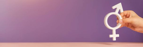 Гетерогенний символ. Прапор з гетерогенним символом в руках на пурпуровому фоні з копіювальним простором. Концепція дискримінації, рівності та гендерної толерантності. Фотографія високої якості - Фото, зображення