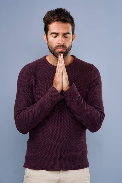 Dear God...Studio shot of a handsome young man praying against a gray background - 写真・画像