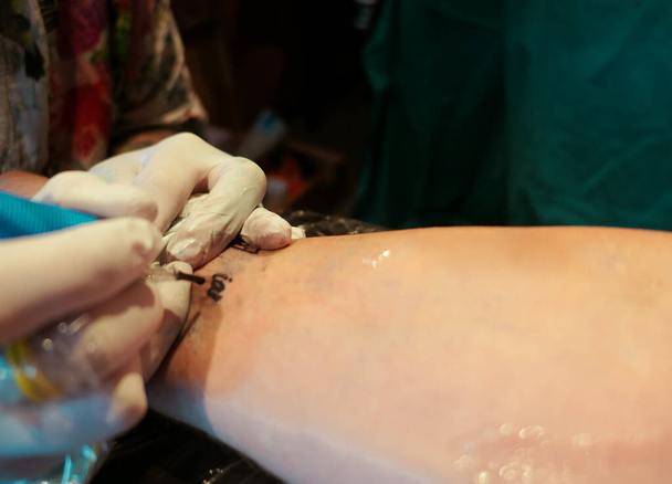 osoba zostaje wytatuowana przez tatuażystę - Zdjęcie, obraz