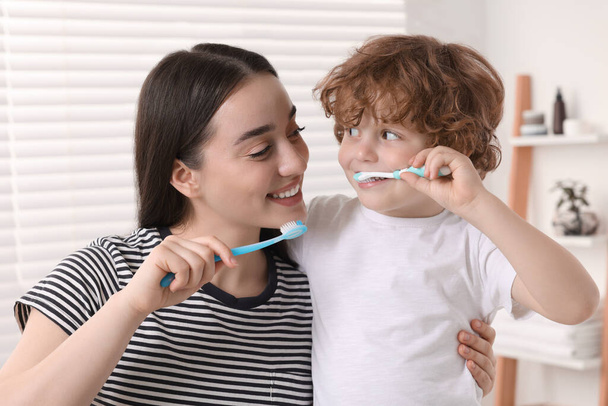 Mother and her son brushing teeth together in bathroom - Foto, imagen